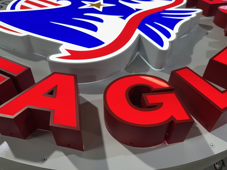 Lit red channel letters and eagle logo, close-up